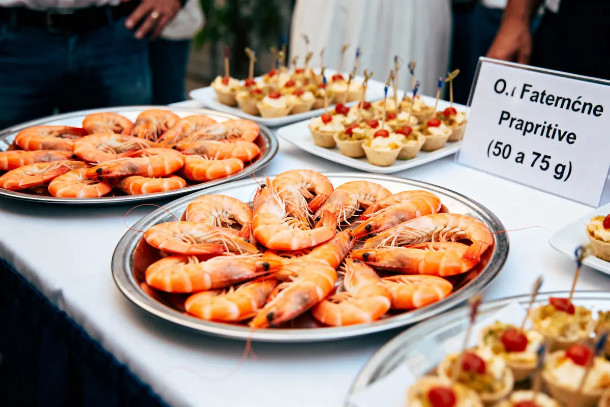 Plateaux de crevettes et amuse-gueules sur une table, avec une étiquette indiquant le poids.